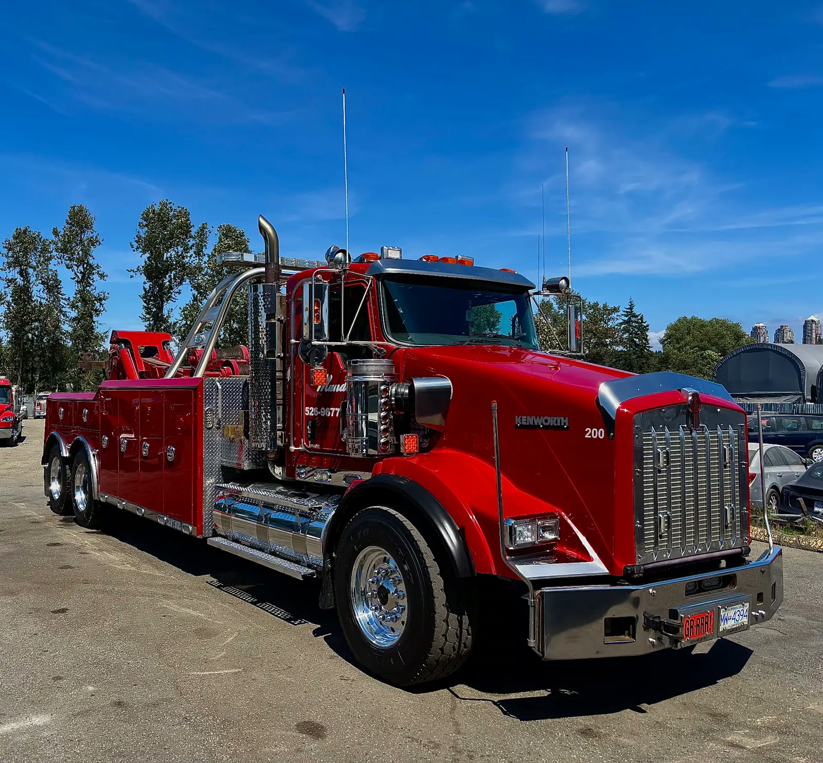 Red Kenworth heavy-duty tow truck detailed to a mirror shine